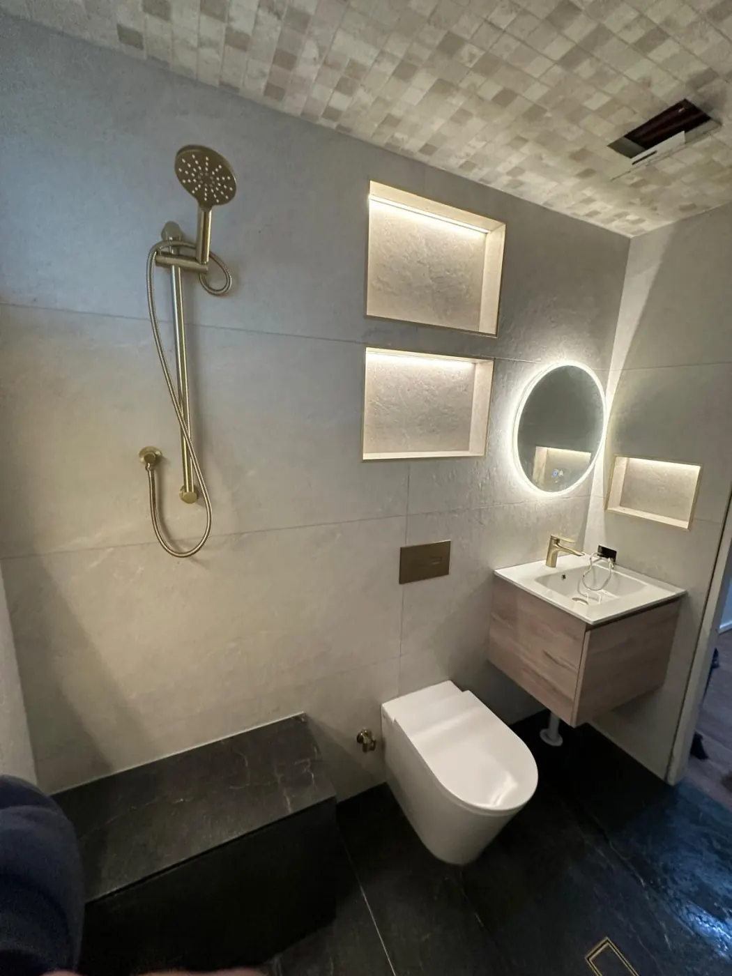 Bathroom with gold tapware and lit niches